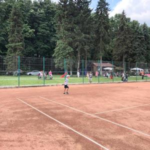 a young girl holding a kite on a tennis court at Casa Mirela in Bucharest