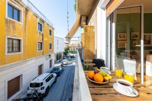 a balcony with a table with fruit and a car on it at Hidesign Athens Plaka Apartment in Acropolis in Athens
