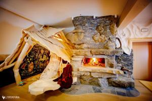 a stone fireplace in the corner of a room at Willa Dorula in Małe Ciche