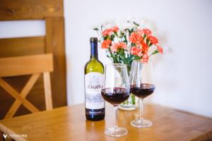 a bottle of wine and two glasses on a table at Willa Dorula in Małe Ciche