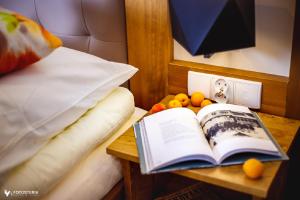 an open book on a table next to a bed at Willa Dorula in Małe Ciche