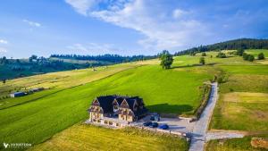 an aerial view of a house on a green field at Willa Dorula in Małe Ciche