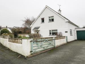 a white house with a gate in front of it at Fernlea in Morfa Nefyn