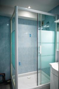 a shower with a glass door in a bathroom at Le Refuge in Lamoura