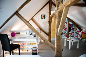 a room with a loft with wooden beams at Gîte La feuille d'Acanthe in Bucilly