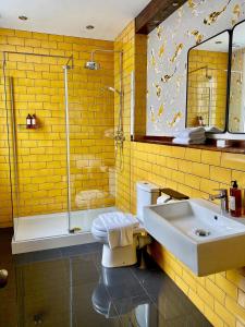 a yellow bathroom with a sink and a shower at The Southern Belle in Brighton & Hove
