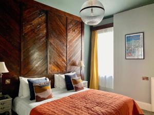 a bedroom with a bed with a large wooden headboard at The Southern Belle in Brighton & Hove