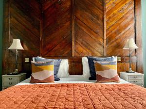 a bedroom with a large bed with a wooden wall at The Southern Belle in Brighton & Hove