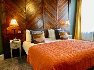 a bedroom with a large bed with a wooden wall at The Southern Belle in Brighton & Hove