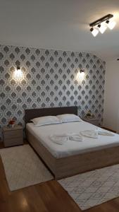 - une chambre avec un lit et deux lumières sur le mur dans l'établissement Pensiunea Turist, à Techirghiol