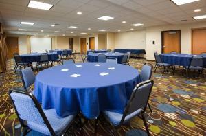 una sala de conferencias con mesas y sillas azules en Holiday Inn Express Hotel & Suites Antigo, an IHG Hotel, en Antigo
