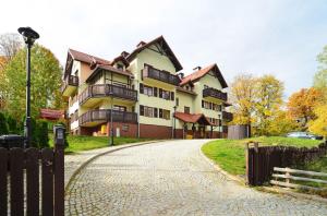 une grande maison avec une allée en face de celle-ci dans l'établissement Apart-Invest Apartament Latte, à Szklarska Poręba