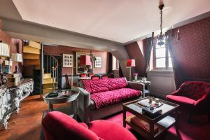 - un salon avec un canapé et des meubles rouges dans l'établissement Parc Royal Appartements, à Paris