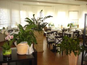 a dining room with tables and chairs with plants at Westend Hotel in Ludwigsburg