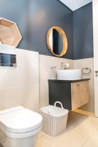 a bathroom with a toilet and a sink and a mirror at Modern Beachfront 2 Bed Apartment 144 Eden on the Bay, Blouberg, Cape Town in Bloubergstrand +35 photos