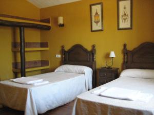 Cette chambre d'hôtel comprend 2 lits avec des draps blancs. dans l'établissement Cortijo El Rey, à El Almicerán