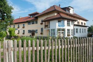 une maison derrière une clôture devant une maison dans l'établissement Hotel Seehof, à Sankt Georgen am Längsee