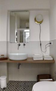 a bathroom with a sink and a mirror and a toilet at La stanza di Camillo in Rome