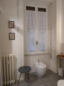 a bathroom with a sink and a window and a chair at La stanza di Camillo in Rome