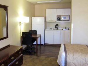 a room with a bed and a desk and a kitchen at Motel 6 Columbus, GA Columbus Airport in Columbus