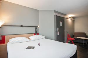 ロリアンにあるibis Lorient Centre Gareのベッドと赤い椅子が備わるホテルルームです。