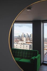 a green couch in a room with a mirror at The Gate London City in London