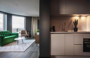 a kitchen and a living room with a green couch at The Gate London City in London