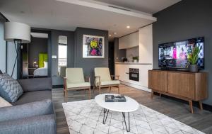 a living room with a couch and a flat screen tv at The Gate ApartHotel London in London