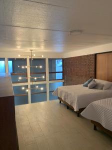 - une chambre avec un lit et un mur en briques dans l'établissement Hotel Residencia del Sol, à Guatemala