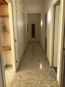 un corridoio vuoto con una stanza con pareti bianche e pavimenti piastrellati di Questa casa non è un albergo CIU-ATR 9390-9 a Roma