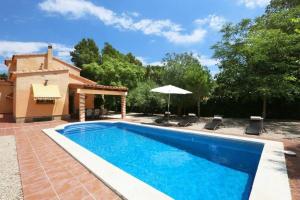 una piscina con sillas y una sombrilla junto a una casa en AME447 Chalet con piscina privada 9x5m y jardín vallado, en Les tres Cales