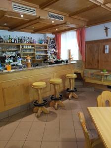 ein Restaurant mit einer Bar mit Hockern davor in der Unterkunft Gasthof Neuratheis in Schnals