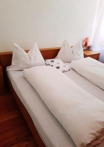 twee bedden met witte lakens en kussens bij Gasthof Neuratheis in Senales