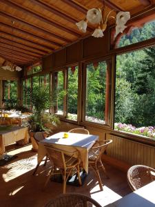 een eetkamer met een tafel, stoelen en ramen bij Gasthof Neuratheis in Senales