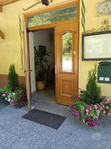 eine Tür zu einem Haus mit Blumen davor in der Unterkunft Gasthof Neuratheis in Schnals