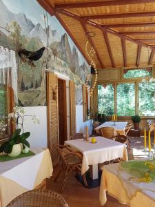 a restaurant with tables and chairs and a painting on the wall at Gasthof Neuratheis in Senales