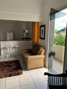 a living room with a couch and a kitchen at Hanna Palace Hotel in Barra do Piraí +19 photos