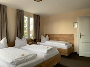 a hotel room with two beds and a window at Hotel & Gutsgasthaus Köberle in Lindau