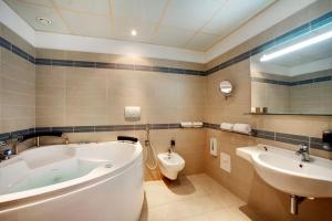 La salle de bains est pourvue d'une baignoire, de toilettes et d'un lavabo. dans l'établissement Cocca Hotel Royal Thai Spa, à Sarnico