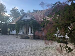 una pequeña casa blanca con techo rojo en Dworek Lipowy Most en Supraśl