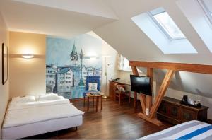 a bedroom with a bed, a desk, and a window at Hotel Adler Zürich in Zurich