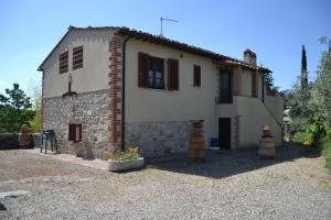 a large white house with a brick at Agriturismo Lo Strettoio in Castelnuovo Berardenga