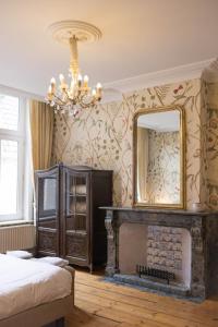 a bedroom with a fireplace and a mirror at Apartments Ridderspoor in Bruges