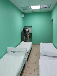a hospital room with two beds and a blue wall at Marseille Hostel in Saint Petersburg
