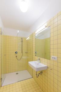 y baño con lavabo y ducha con espejo. en Hus Appartement - Nr. 1 en Valdaora