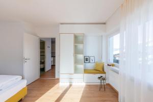 a bedroom with white walls and a desk and a window at Hus Appartement - Nr. 2 in Valdaora