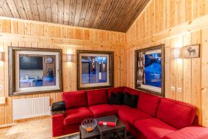 a red couch in a room with wooden walls at Malin Resort in Abborrträsk