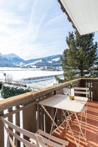 una mesa y sillas en una terraza con vistas al agua en Hus Appartement - Nr. 3 en Valdaora