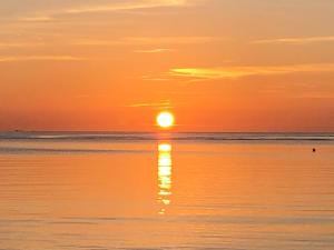 puesta de sol en la playa con puesta de sol en Borgo Spiaggia Vista Mare, en Isola Rossa