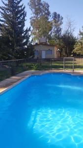 una gran piscina azul frente a una casa en Finca Casiana en 